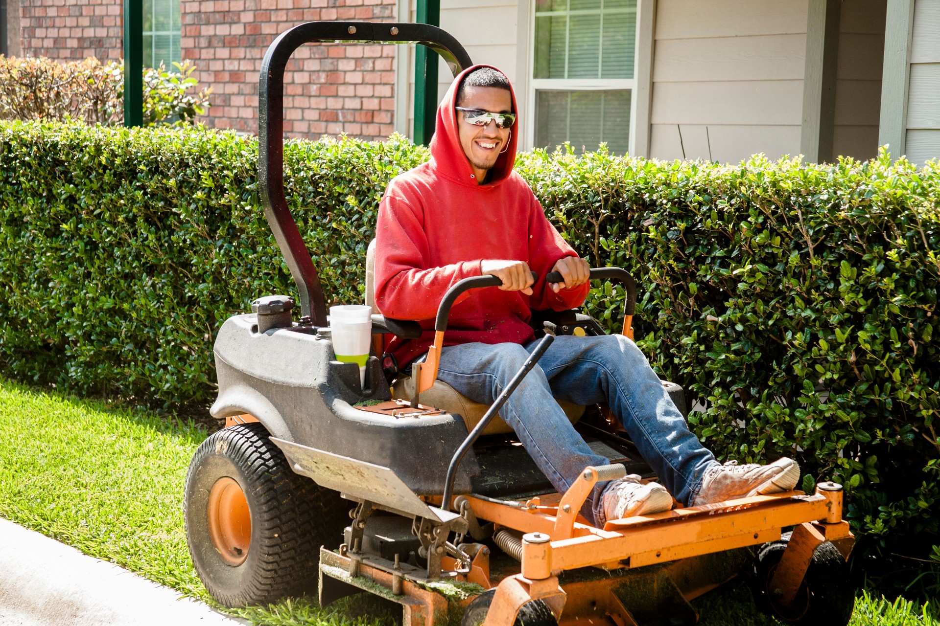 Working class.  Man mows lawn using industrial lawn mower.